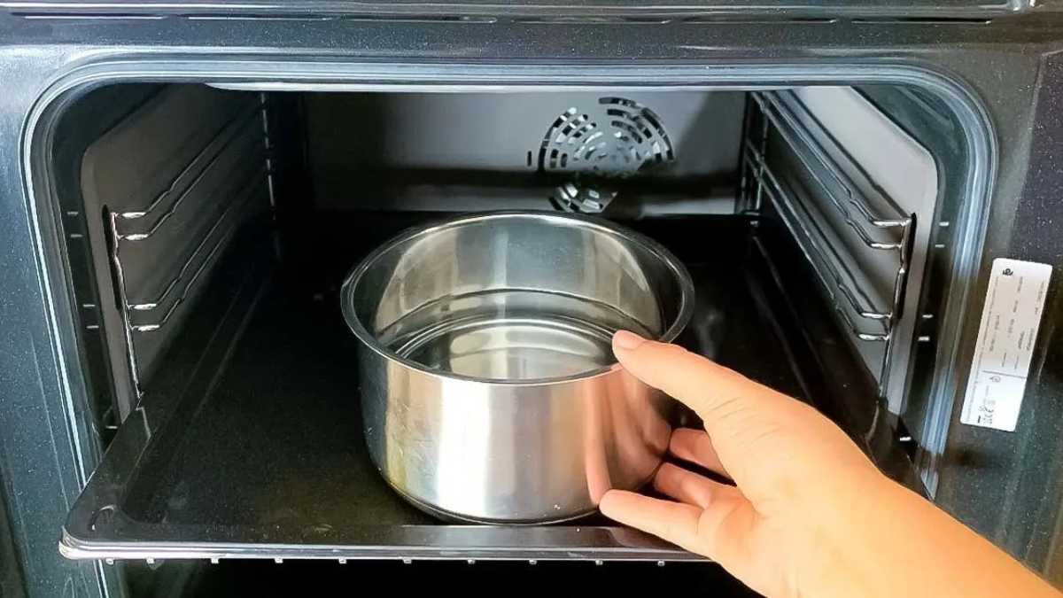 Remplissez une casserole d’eau et mettez-la au four. La saleté se détachera des parois et de la grille